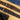 Two cork belts, one brown and one black, on a wooden surface with jeans in the background.