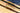 Three cork belts with gold buckles on a wooden surface, one of which is partially under a blue denim fabric.
