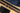 Black cork belt, sunglasses, and blue jeans on a wooden surface