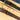 Three cork belts with engraved text on a wooden surface